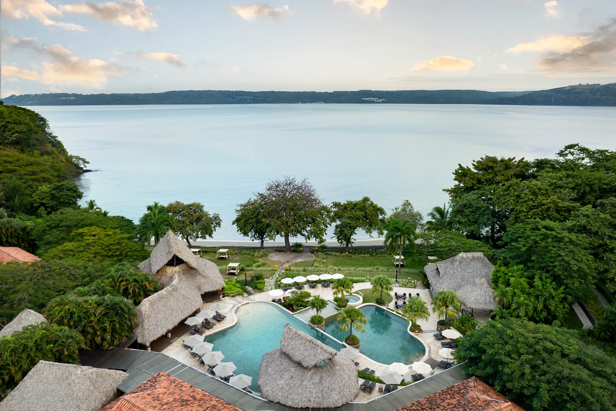 Aerial view of the main pool at Secrets Papagayo Costa Rica surrounded by tropical greenery and ocean views.