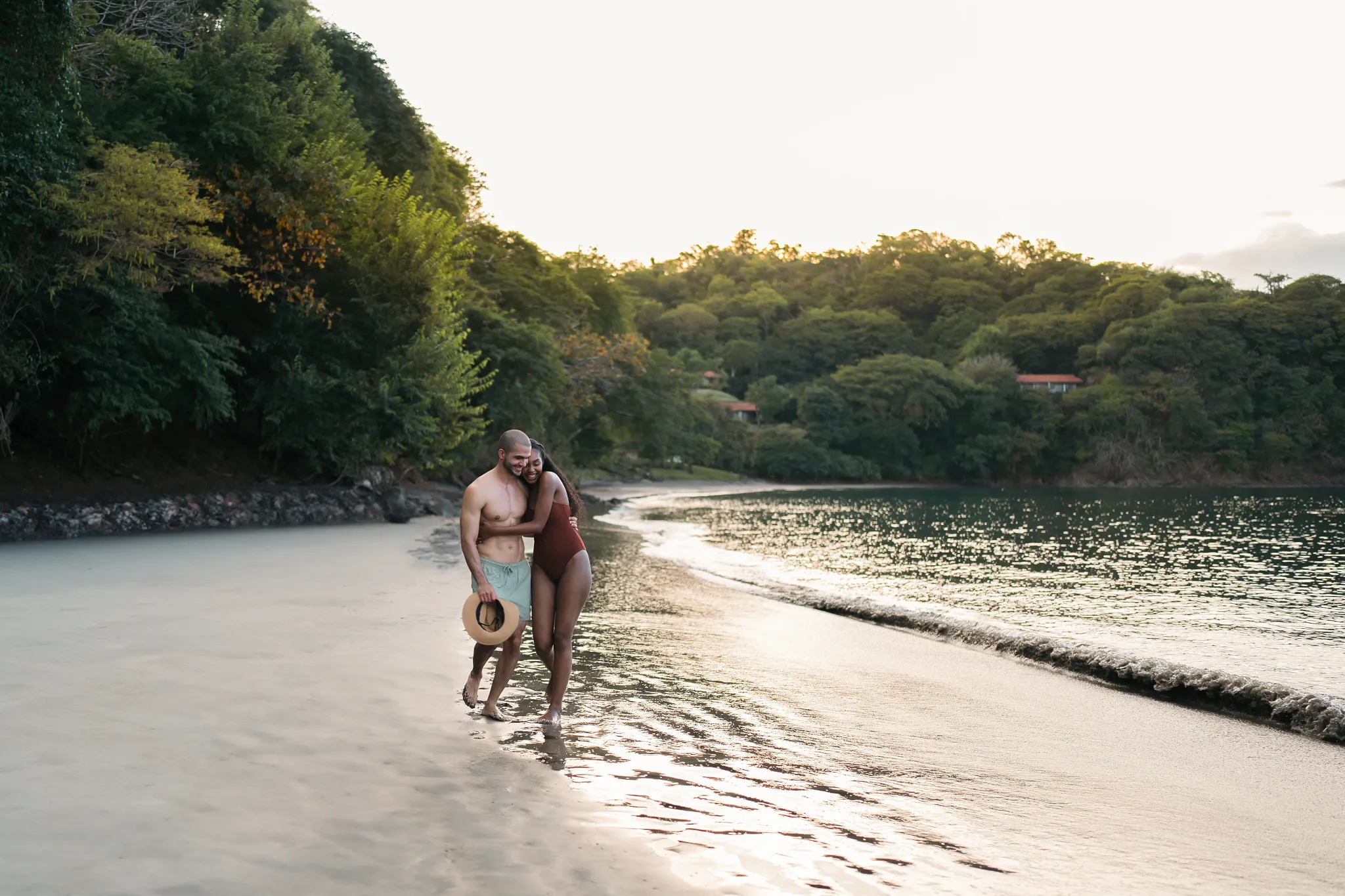 Romantic couple walking along the secluded beach at Secrets Papagayo Costa Rica, surrounded by lush tropical landscapes.