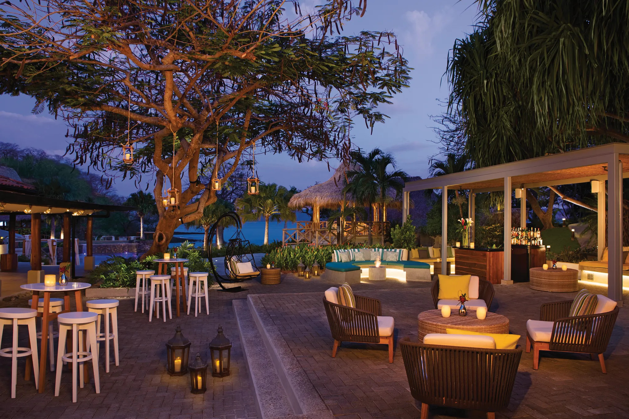 Evening view of the resort plaza with lounge seating and ambient lighting at Secrets Papagayo Costa Rica.