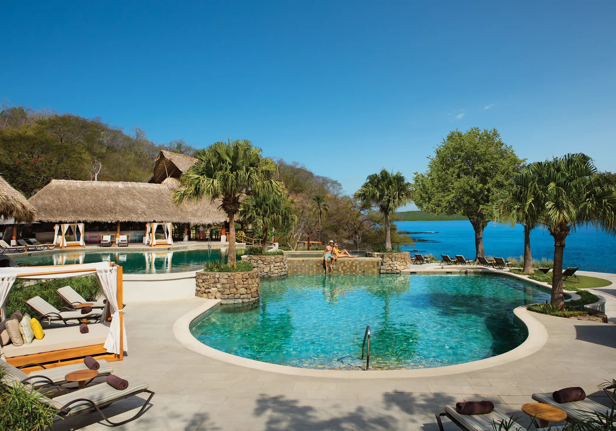 Panoramic daytime view of the main pool at Secrets Papagayo Costa Rica overlooking the Pacific Ocean.
